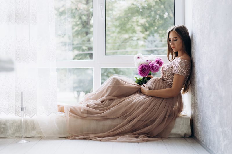 Maternity photography ideas - Sensitive portrait of pregnant woman. Expecting lady lies on the