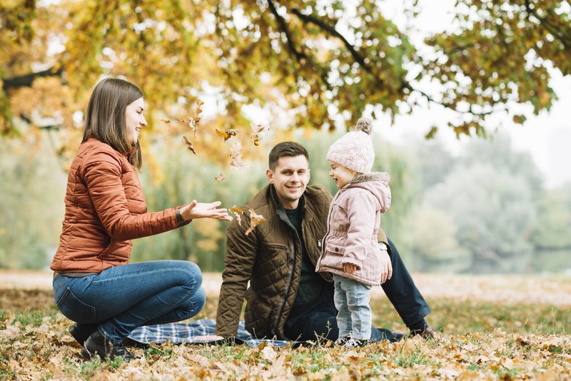 family-playing-with-leaves-autumn-forest