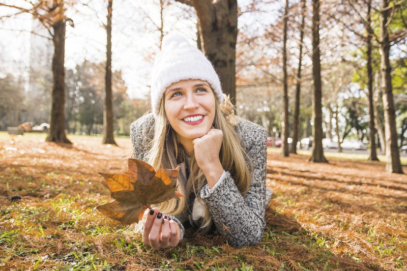 female-lying-fall-forest-smiling