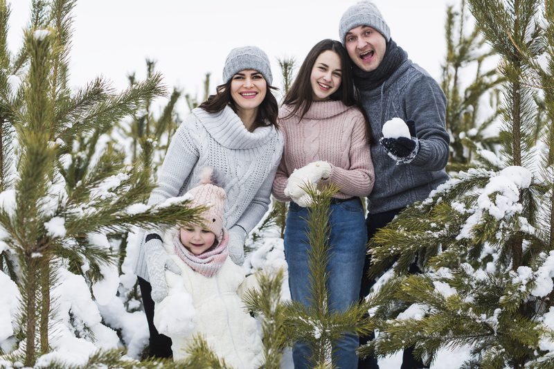 happy-family-posing-near-spruces