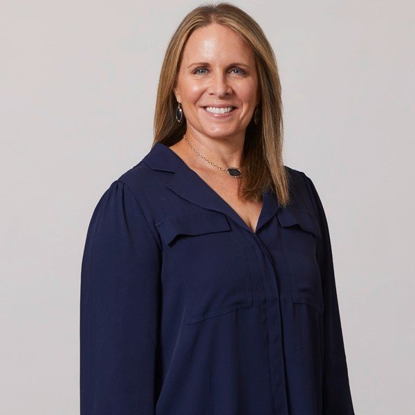 blonde woman navy blue blouse light background