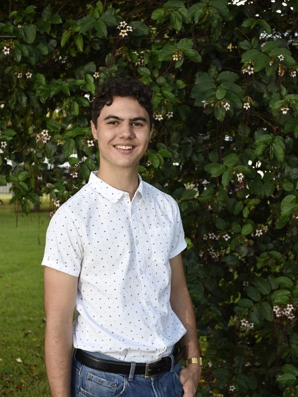 young man white shirt green bush