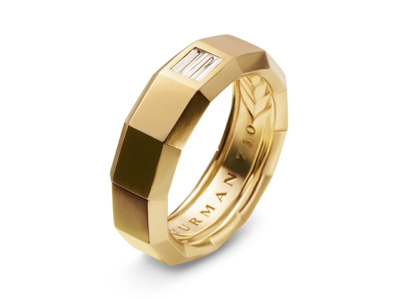 Gold ring with a faceted geometric band, a small rectangular diamond, and an engraved inner band.